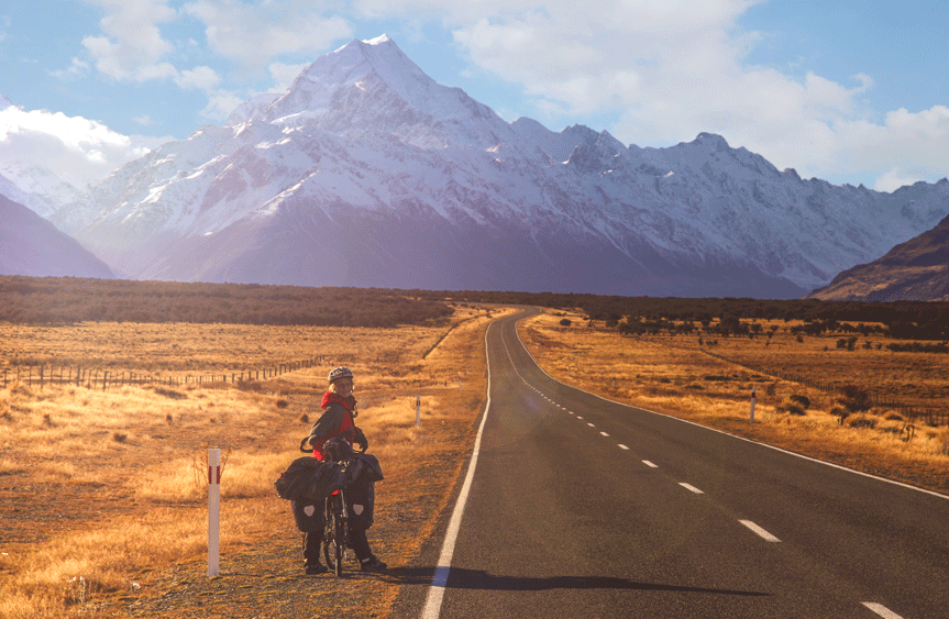 Women on cycling holiday in New Zealand cycling towards Mount Cook with bike panniers cycling travel insurance