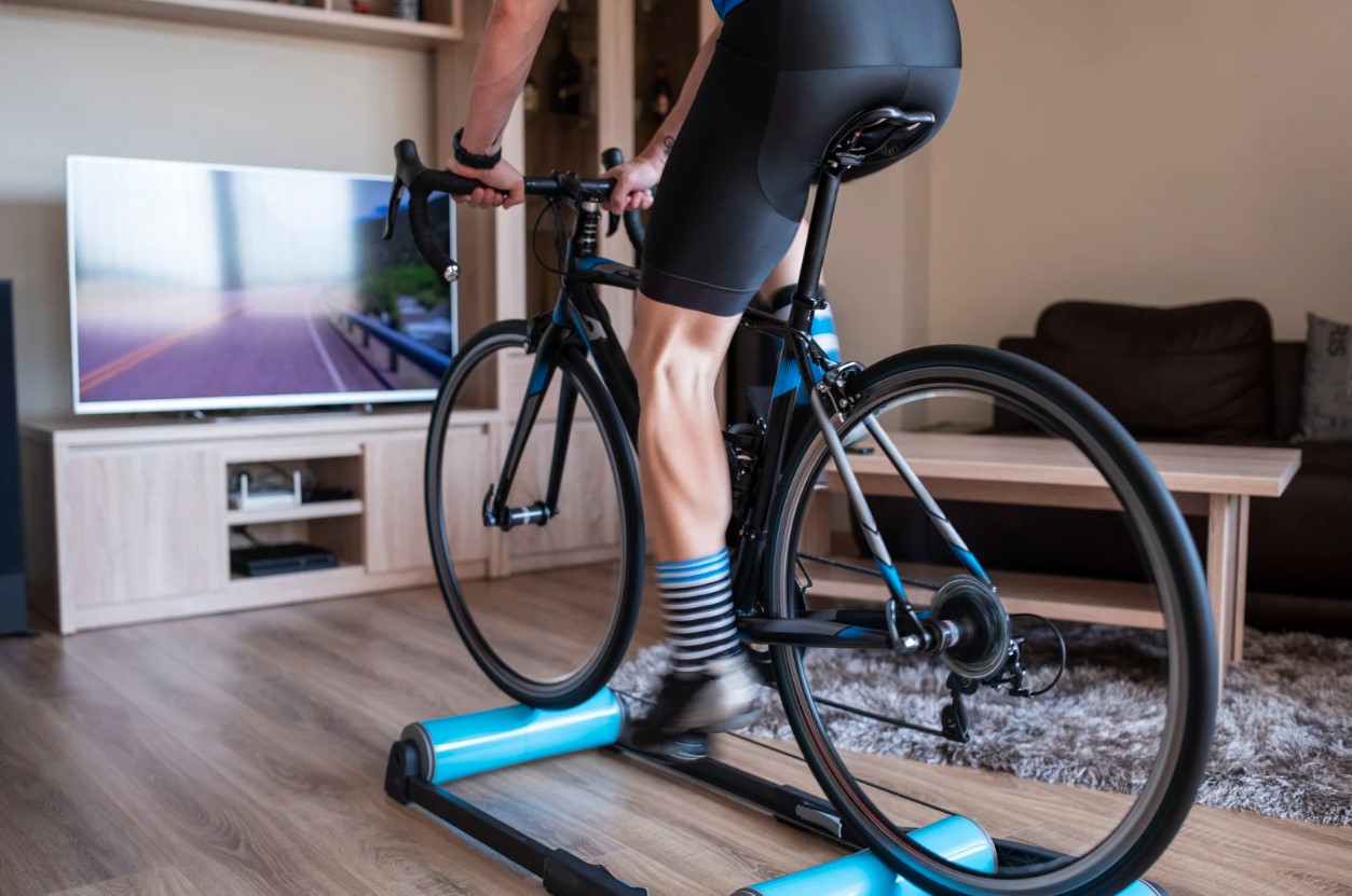 a man riding his bicycle indoors on rollers